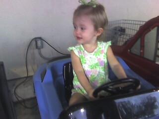 Ella rides the play car at HEB